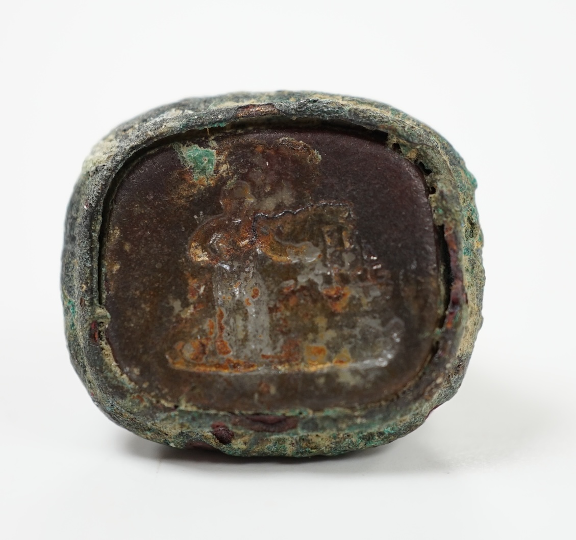 A Roman base metal intaglio seal, carved with a figure?, 20mm. Condition - poor